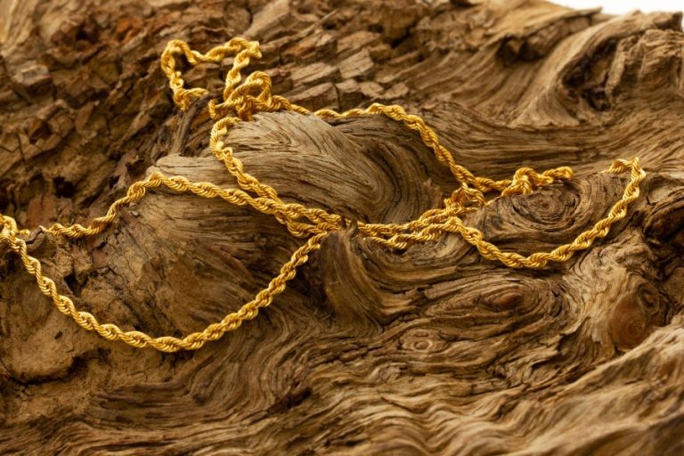 Une loupe inspecte le poinçon gravé sur un collier en or