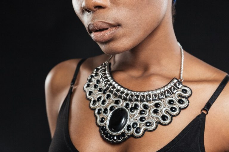 Un collier statement doré aux maillons larges attire la lumière sur un décolleté élégant