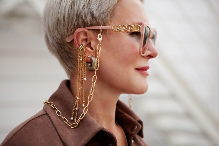 Femme aux cheveux courts portant de fines boucles d’oreilles en argent qui mettent en valeur sa mâchoire