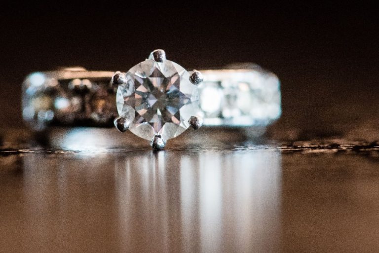 Bijoutier examinant un diamant sur une bague à l’aide d’une loupe grossissante