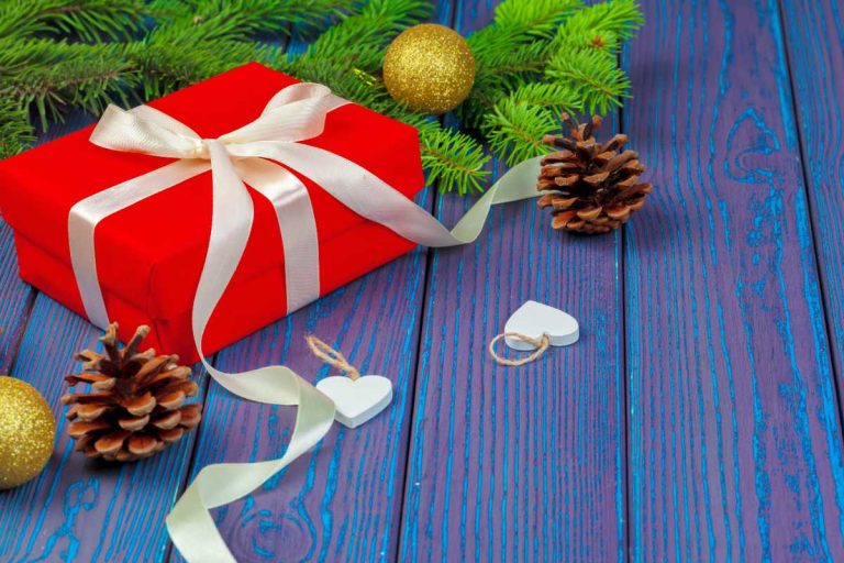 Une bague dorée repose dans un écrin décoré aux couleurs de Noël