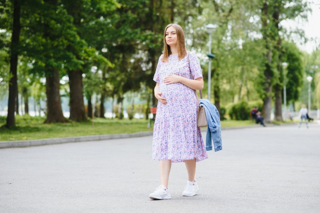 Une femme enceinte portant une robe avec du basket