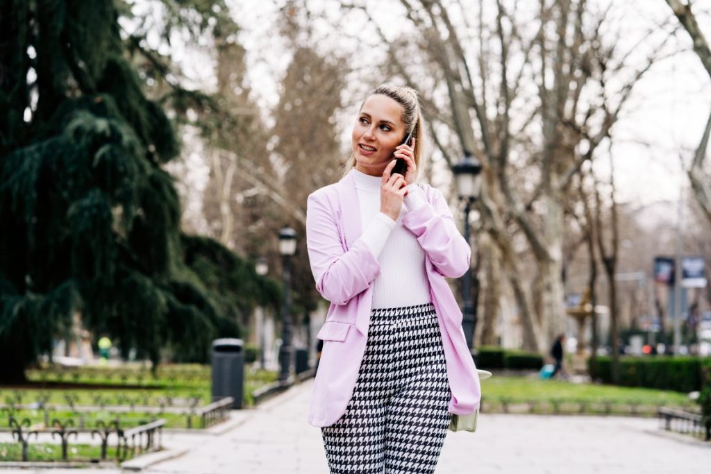 Une femme qui porte un pantalon à carreaux et un blazzer long
