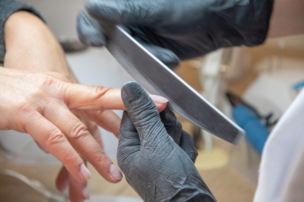 Une esthéticienne faisant un limage des ongles d'une femme