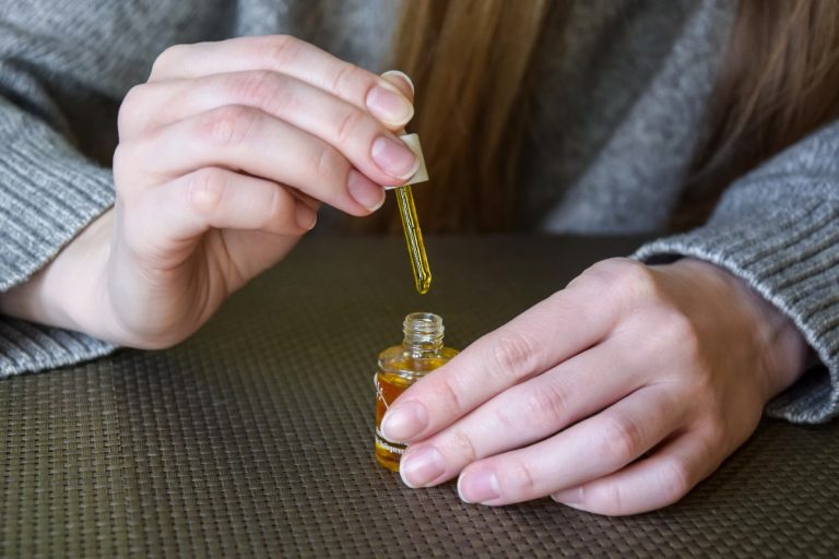 Une personne qui applique de l'huile de ricin sur ses ongles
