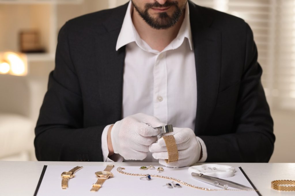 Un expert en bijoux qui examine une montre en or