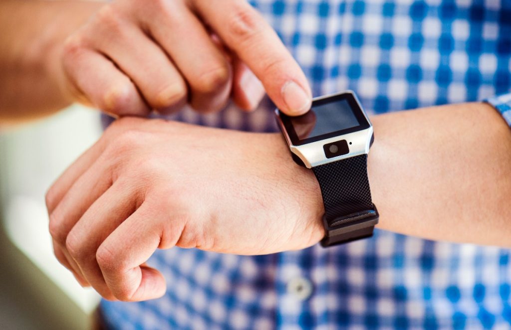 Main d'un homme appuyant sur la montre