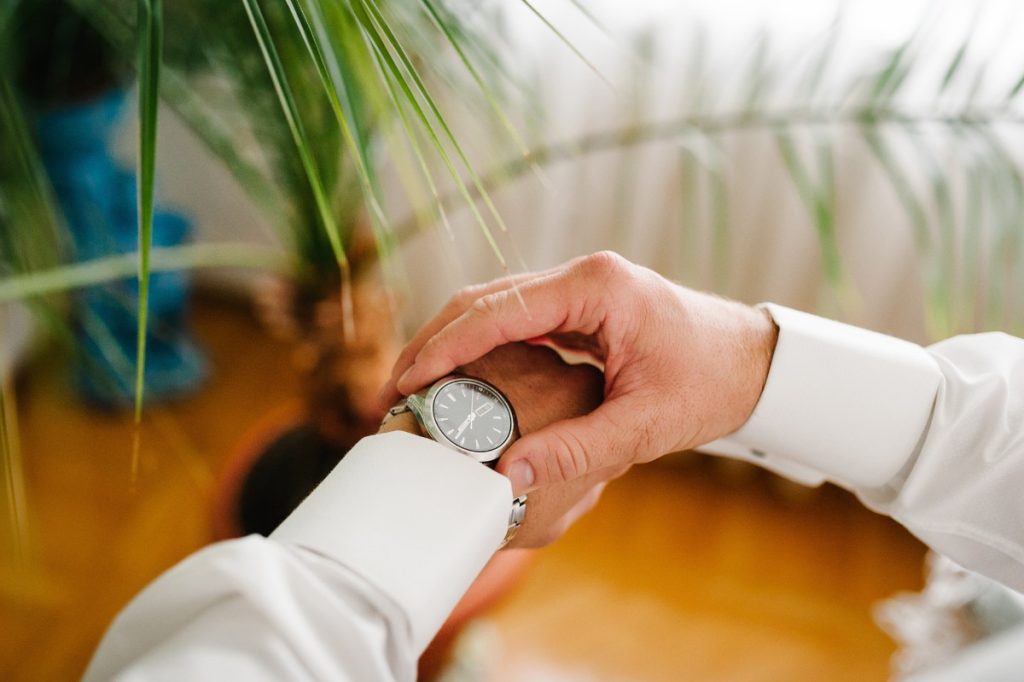 Un homme en chemise qui ajuste une montre