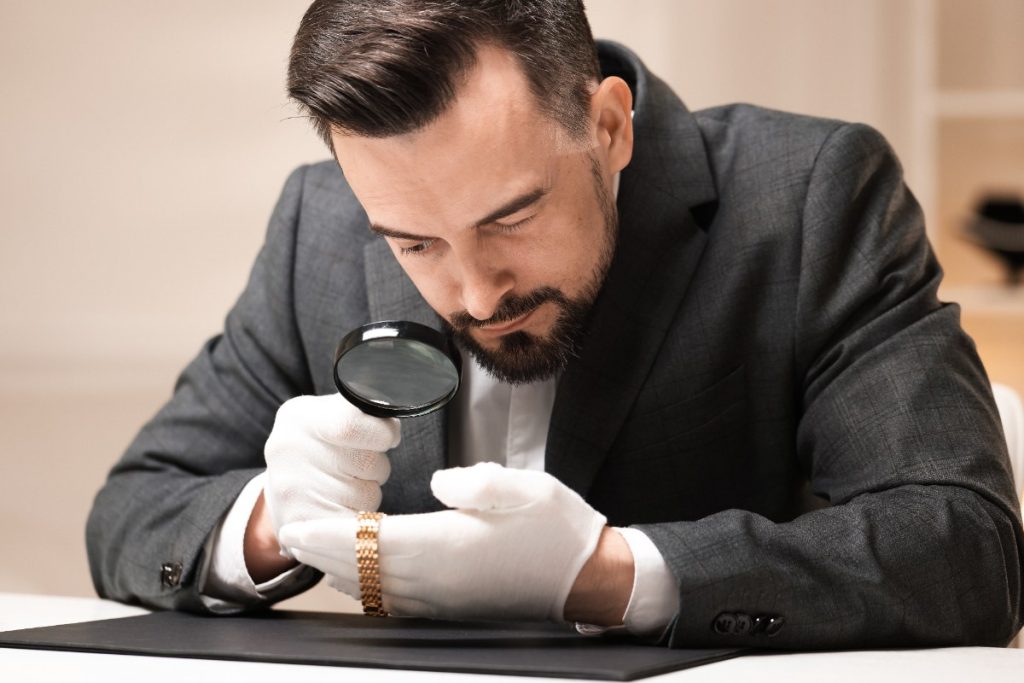 Un homme portant un gant et inspectant une montre