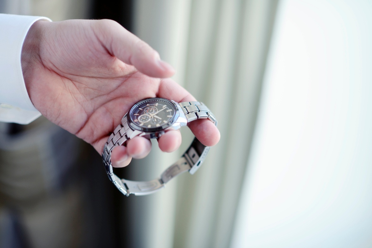 Main tenant une montre bracelet