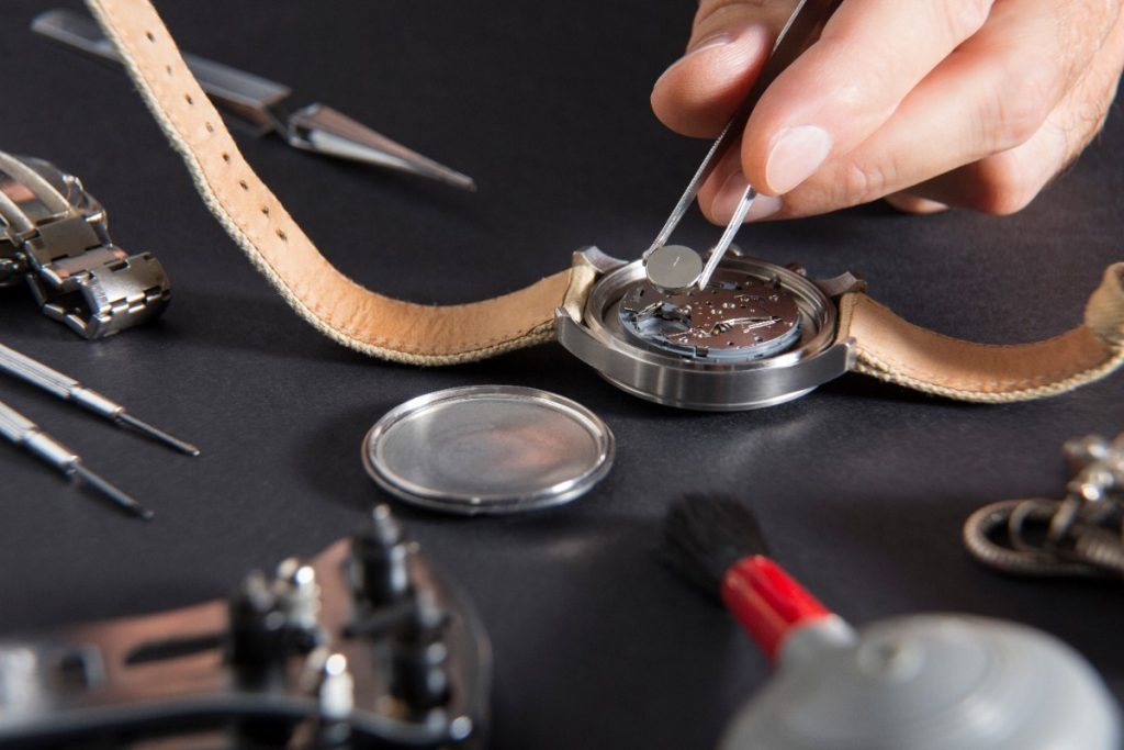Une personne qui remplace la pile d'une montre