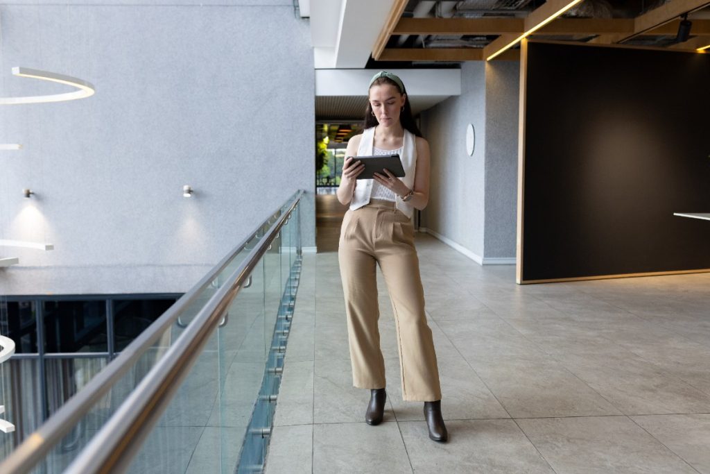 Une femme habillée en petit haut blanc avec un pantalon beige