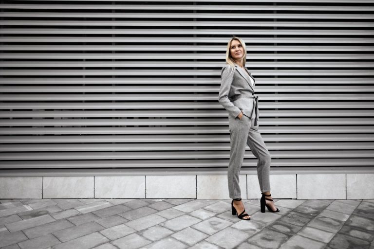 Une femme habillée en tailleur gris et talon noir
