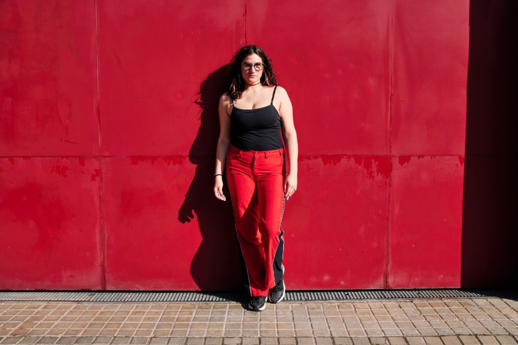 Une femme ronde portant un pantalon rouge et un haut noir