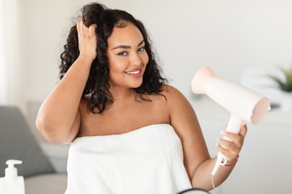 Une femme qui sèche ses cheveux bouclés