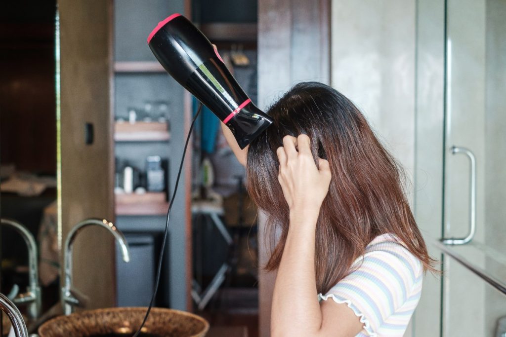Une jeune femme qui sèche les cheveux