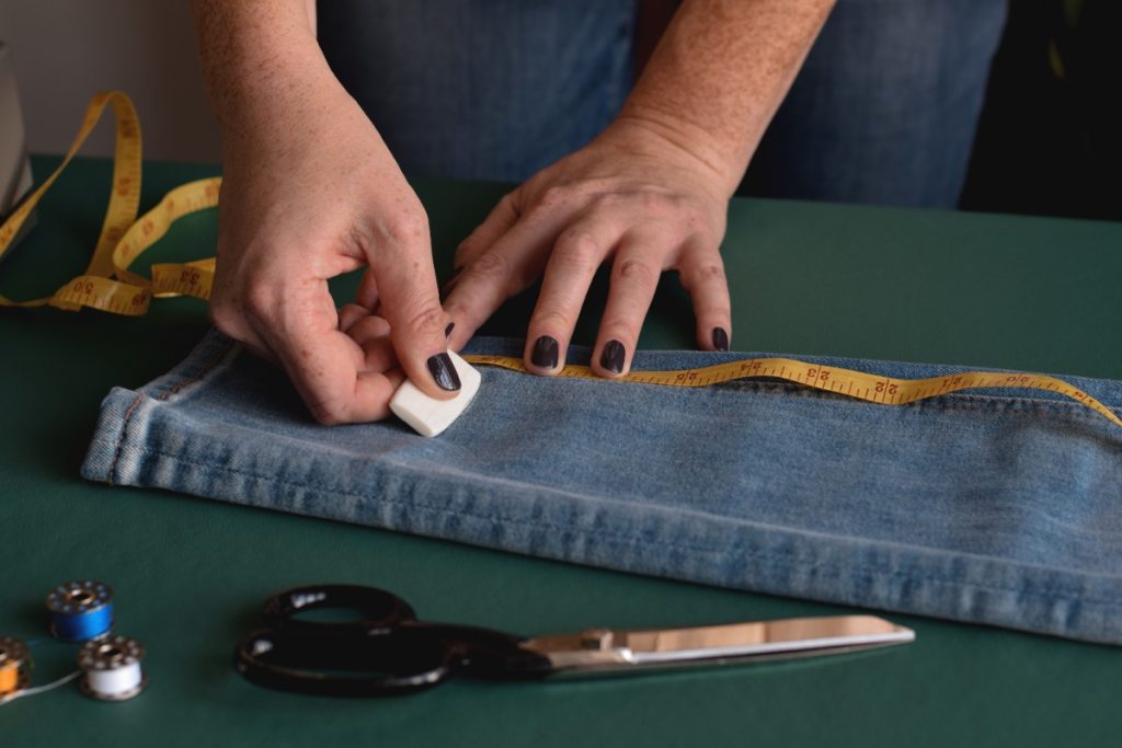 Mains mettant une marque sur un pantalon jean