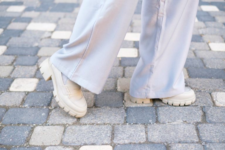 Une personne portant un pantalon large avec des chaussures grises