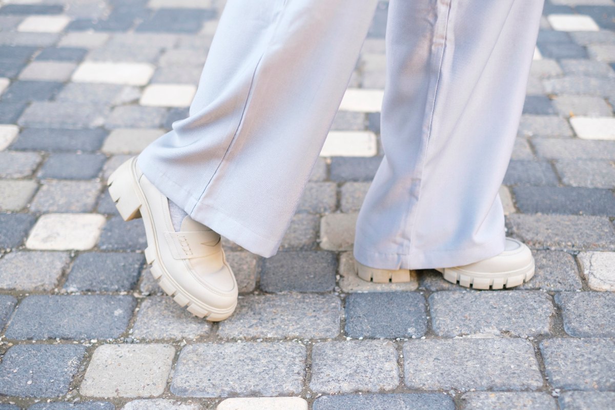 Une personne portant un pantalon large avec des chaussures grises