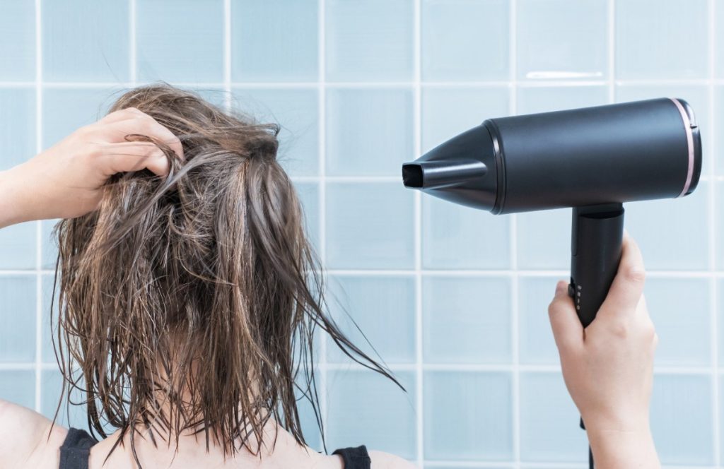 Une personne séchant ses cheveux