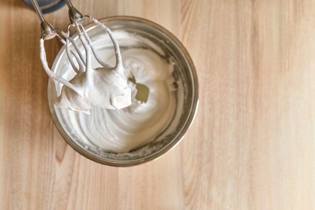 Crème fouettée dans un bol sur une table en bois