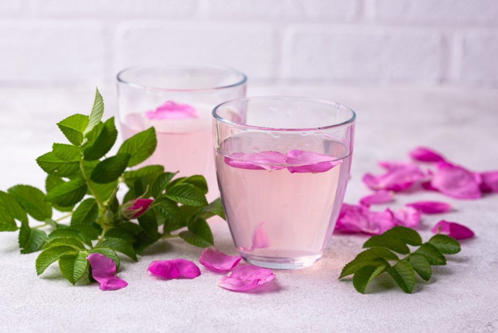 Deux verres d'eau de rose avec des feuilles vertes