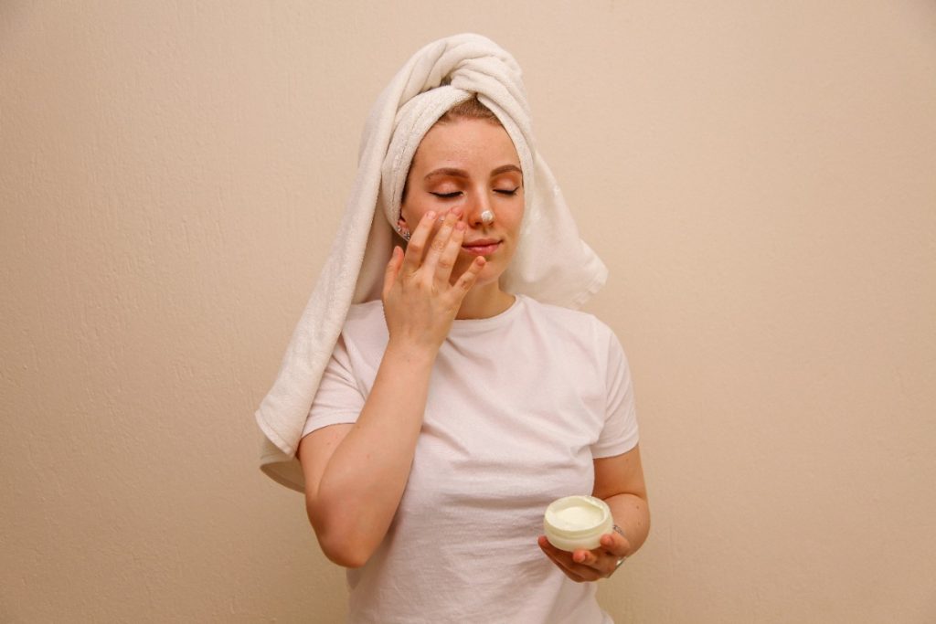 Une femme appliquant du beurre de karité sur son visage