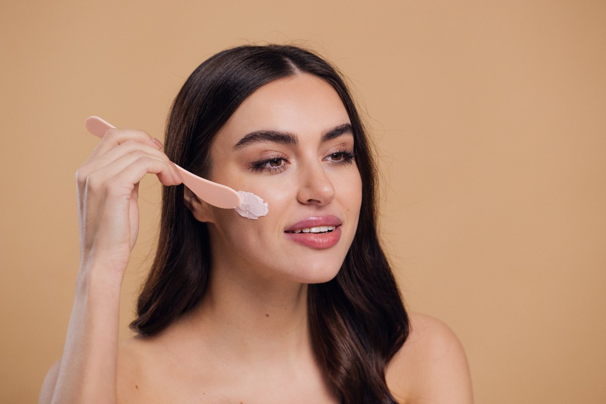 Une femme appliquant de la crème sur le visage
