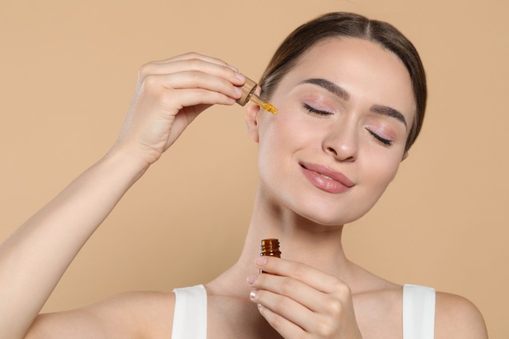 Une femme appliquant de l'huile sur son visage