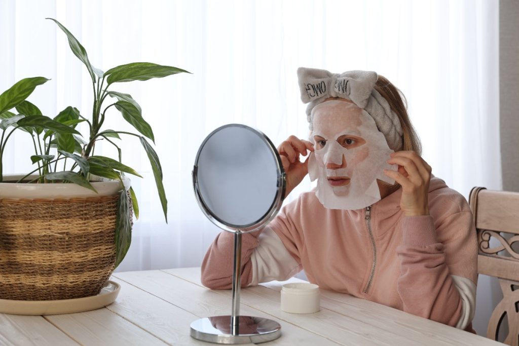 Une femme appliquant du masque sur son visage
