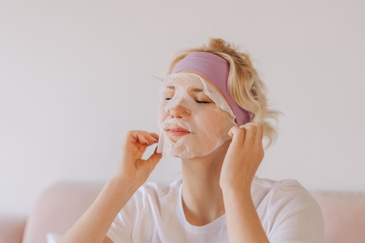 Une femme avec un bandeau violet qui applique un masque du visage