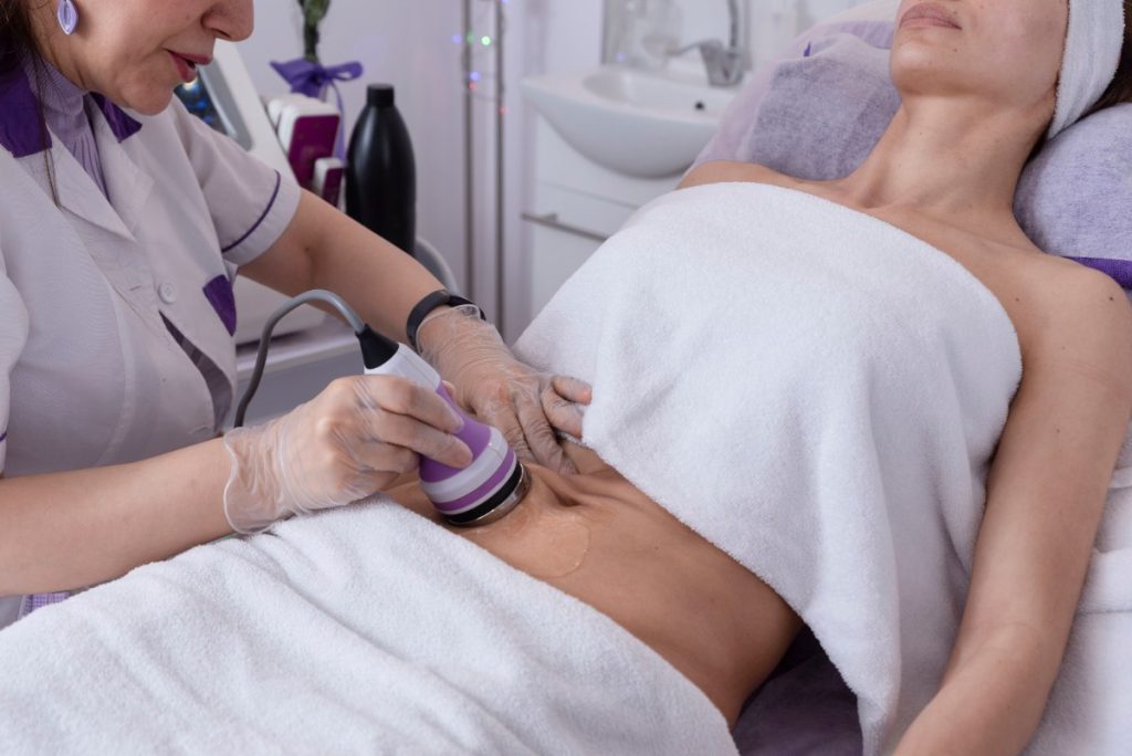 Une femme recevant un traitement de cavitation pour éliminer la graisse abdominale