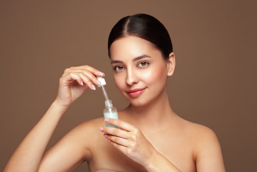 Une femme tenant un flacon de sérum pour le visage