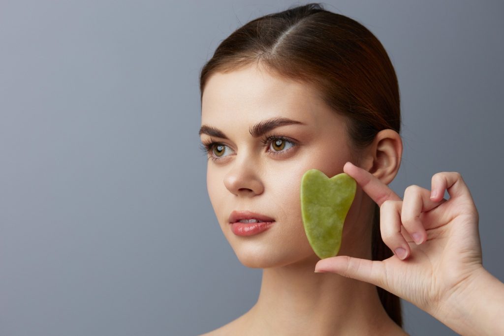 Une femme tenant une pierre de gua sha