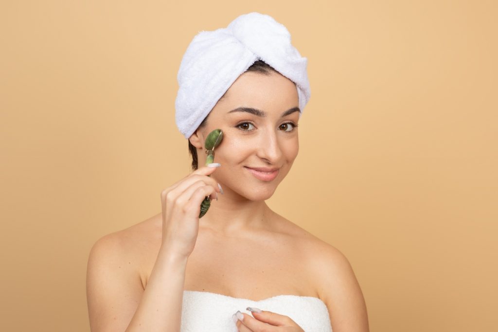 Une femme utilisant un rouleau facial en jade