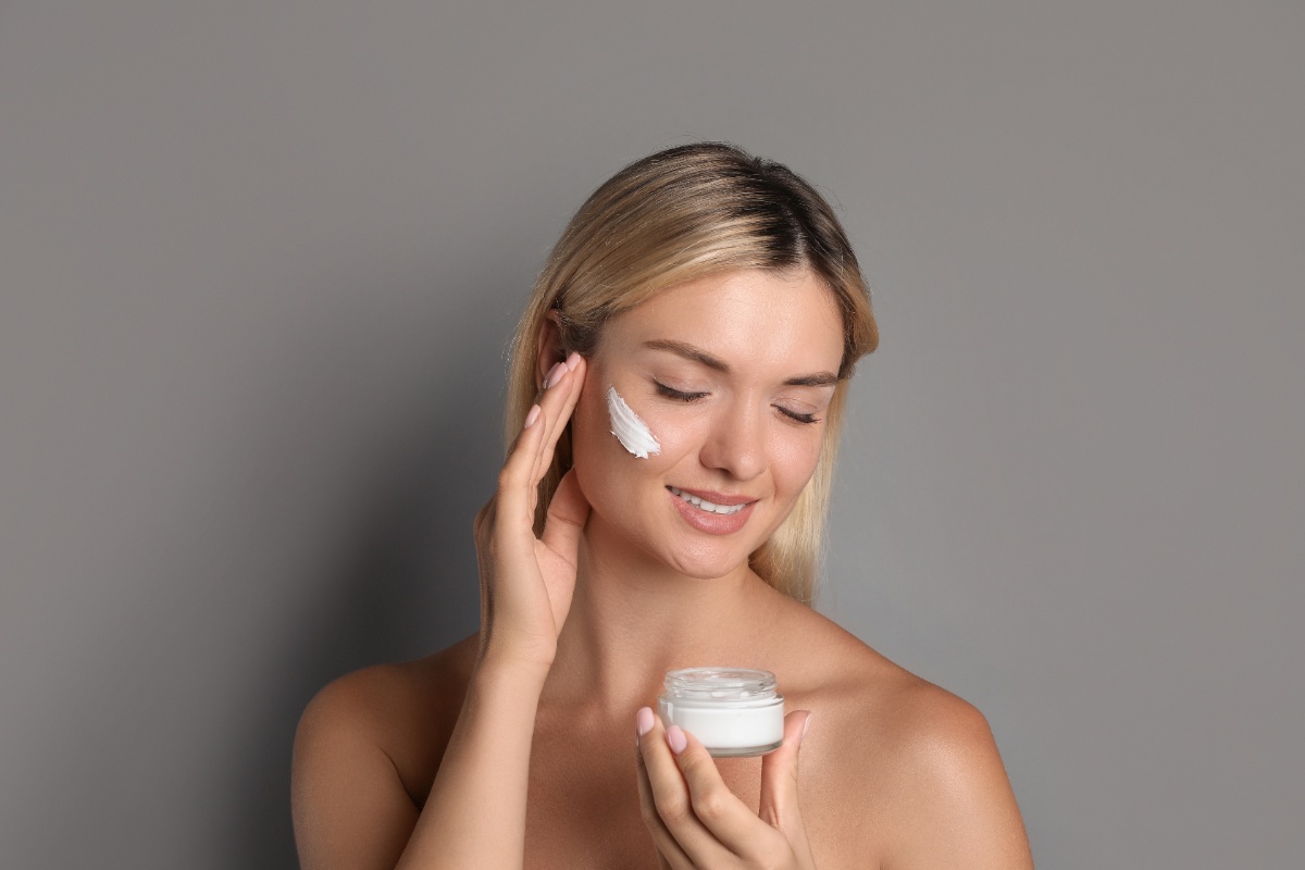 Une jeune femme appliquant de la crème sur le visage