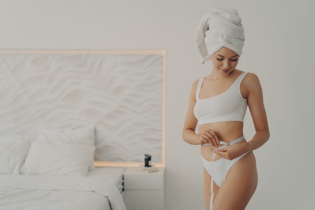 Une jeune femme qui mesure sa taille