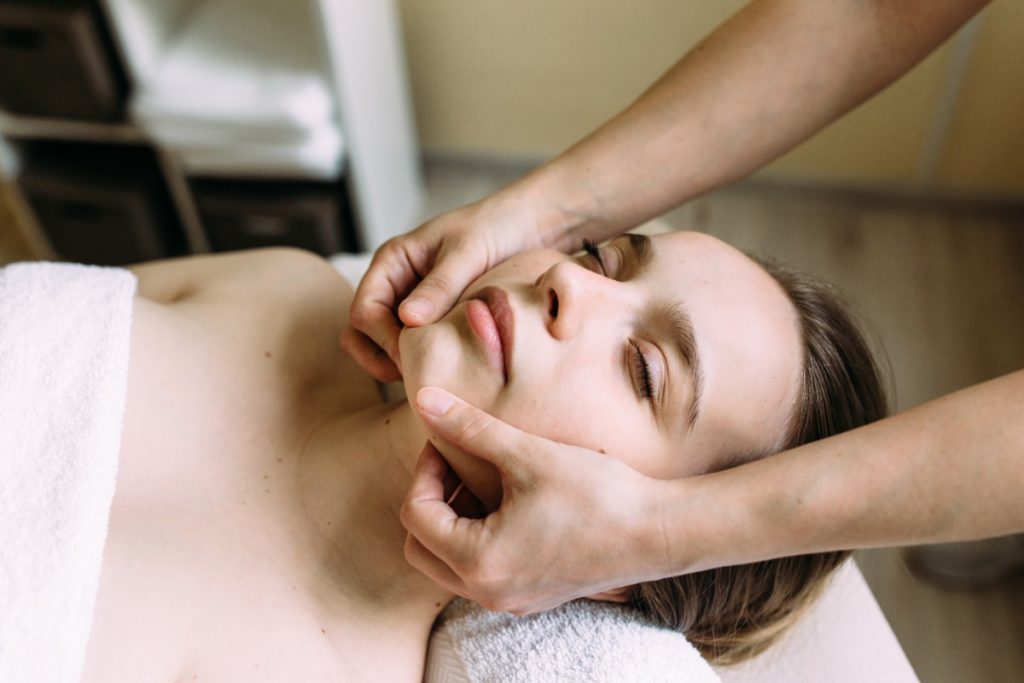 Une jeune femme recevant un massage facial