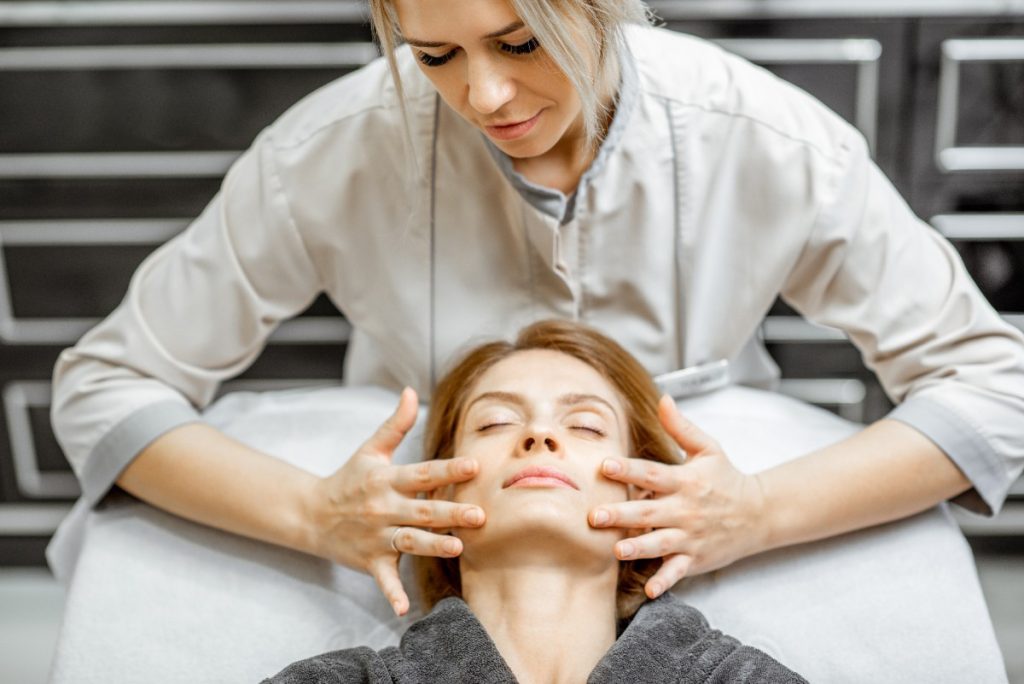 Une professionnelle massant le visage d'une femme