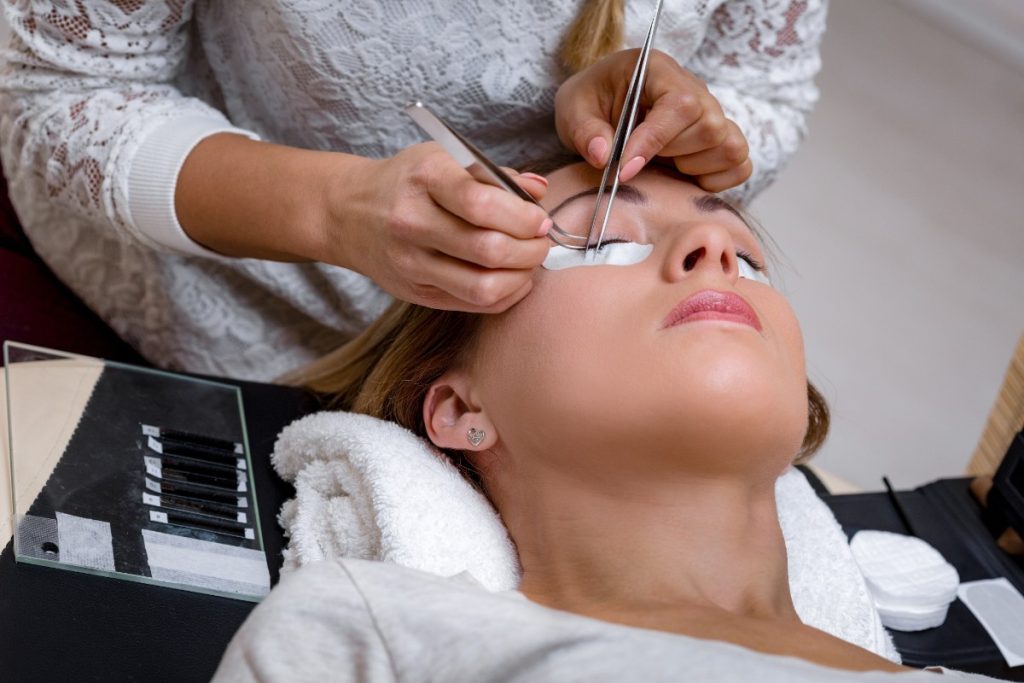 Une professionnelle retirant l'extension cils d'une femme